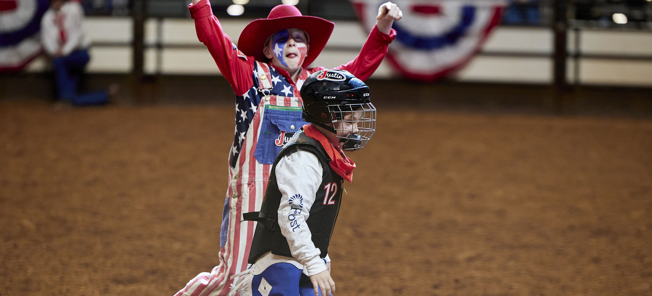 A young rodeo clown cheering on a kid competitor in Mutton Bustin